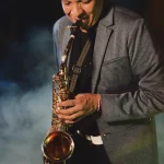 Jimmy Sax interpretando una melodía con su saxofón durante una presentación en un evento de noche.